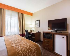 a hotel room with a bed and a flat screen tv at Econo Lodge Inn & Suites East Houston I-10 in Houston