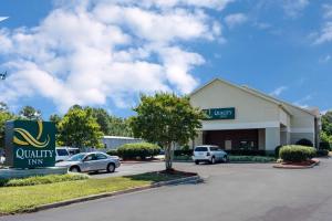 a building with cars parked in a parking lot at Quality Inn Warsaw near Rappahannock River in Warsaw