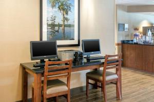 uma secretária com dois monitores de computador e duas cadeiras em Comfort Inn & Suites Biloxi-D'Iberville em Biloxi