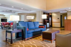 ein Wohnzimmer mit einem blauen Sofa und einem Tisch in der Unterkunft Comfort Inn & Suites Biloxi-D'Iberville in Biloxi