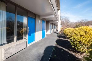 an empty sidewalk next to a building with blue windows at Econo Lodge Elkridge near Arundel Mills in Elkridge