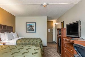 a hotel room with a bed and a flat screen tv at Quality Inn Bucyrus North in Bucyrus