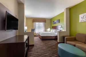 a hotel room with a bed and a television at Sleep Inn & Suites Millbrook - Prattville in Millbrook