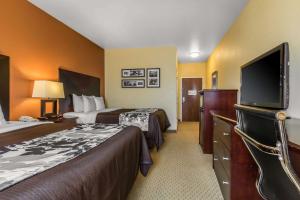 a hotel room with two beds and a flat screen tv at Sleep Inn & Suites Huntsville near US Space & Rocket Center in Huntsville