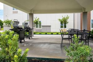 a patio with tables and chairs in front of a building at MainStay Suites Geismar - Gonzales in Geismar