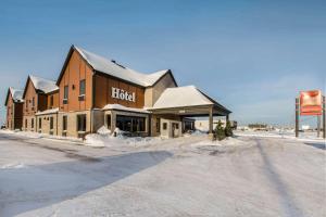 a building on the side of a snow covered street at Econo Lodge Inn & Suites in Saint-Apollinaire