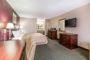 Habitación de hotel con cama y TV de pantalla plana. en Quality Inn, en Tifton