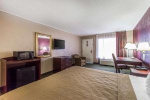 Una habitación de hotel con una cama y un escritorio y una habitación. en Quality Inn, en Tifton 11 fotos más