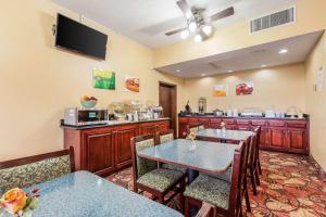 a dining room with two tables and a kitchen at Quality Inn in Tifton