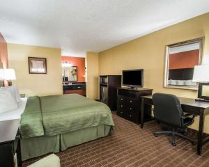 a hotel room with a bed and a desk with a computer at Quality Inn near Blue Spring in Orange City