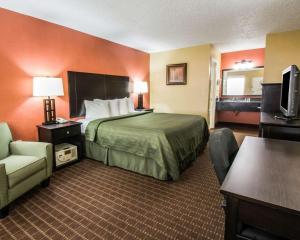 une chambre d'hôtel avec un lit et une chaise dans l'établissement Quality Inn near Blue Spring, à Orange City