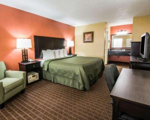 a hotel room with a bed and a chair at Quality Inn Orange City in Orange City