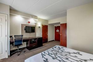 フレデリックにあるSleep Innのベッド、デスク、テレビが備わるホテルルームです。