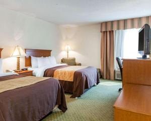 a hotel room with two beds and a television at Quality Inn & Suites Near Amish Country in Rushville