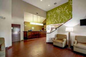 a living room with two chairs and a staircase at Sleep Inn Frederick - Ballenger Creek in Frederick