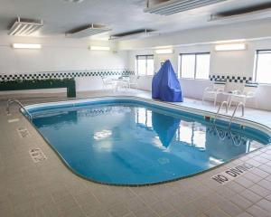 a large swimming pool in a room with tables and chairs at Quality Inn near I-72 and Hwy 51 in Forsyth