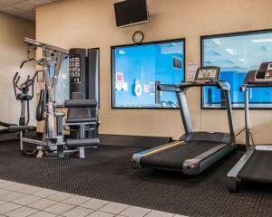 un gimnasio con dos máquinas de correr y una gran ventana en American Inn & Suites, en Waterford