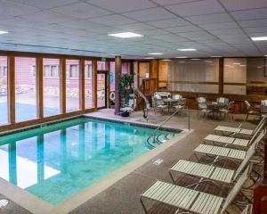 - une piscine avec des chaises longues et une table dans l'établissement Quality Inn & Suites, à Goshen