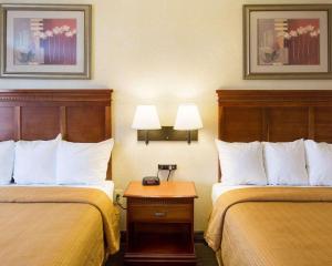 a hotel room with two beds and a table at Quality Inn Takoma Park in Takoma Park