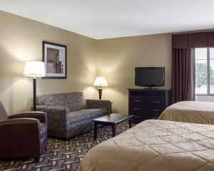 a hotel room with a couch chair and a television at MainStay Suites Bismarck in Bismarck