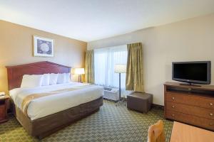 a hotel room with a bed and a flat screen tv at Quality Inn Fairmont in Fairmont