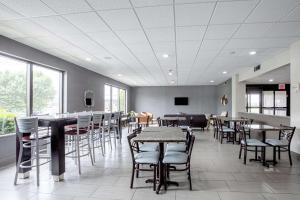 Un restaurante con mesas y sillas en una sala. en Quality Inn Holly Springs South, en Holly Springs