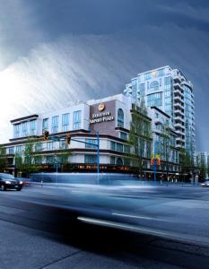 a building on a street with a car in front of it at Executive Hotel Vancouver Airport in Richmond