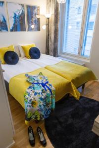 a bedroom with a bed with a yellow blanket and shoes at Antintorni Apartment 14 in Pori