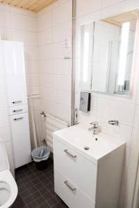 a white bathroom with a sink and a mirror at Antintorni Apartment 14 in Pori
