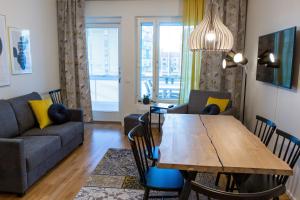 a living room with a table and a couch at Antintorni Apartment 14 in Pori