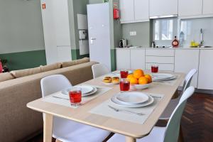 une table avec des plaques et des bols d'oranges dans l'établissement Apperols Feeling Apartment 2A, à Lisbonne