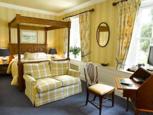 Chedworth的住宿－The Inn at Fossebridge，一间卧室配有一张床、一把椅子和一张书桌