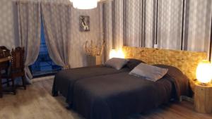 a bedroom with two beds and two lamps in it at Le Clos des Aramons in Bernis