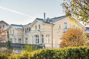 a large cream colored house with windows at Villa am Strand in Ahlbeck