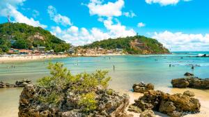 a beach with a bunch of people in the water at Pousada Manaia in Morro de São Paulo