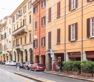 a row of buildings on a street with parked cars at BolognaRoomscom - Santo Stefano Apartments in Bologna