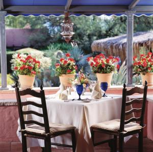 uma mesa com duas cadeiras e flores sobre ela em Arizona Inn em Tucson