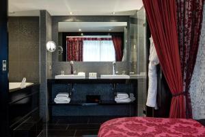 a bathroom with a bed and a sink and a mirror at The Pavilions Amsterdam, The Toren in Amsterdam