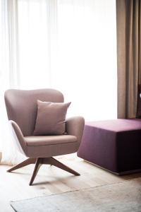 a chair and a ottoman in front of a window at Lamondis in Castelrotto