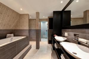 a bathroom with two sinks and a tub at The Pavilions Amsterdam, The Toren in Amsterdam +37 photos