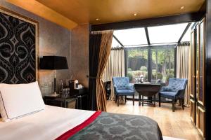 a bedroom with a bed and a table and chairs at The Pavilions Amsterdam, The Toren in Amsterdam