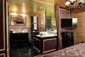 a bedroom with a shower with a television and a bed at The Pavilions Amsterdam, The Toren in Amsterdam
