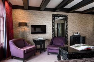a room with two purple chairs and a mirror at The Pavilions Amsterdam, The Toren in Amsterdam