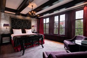 a bedroom with a bed and a couch and windows at The Pavilions Amsterdam, The Toren in Amsterdam
