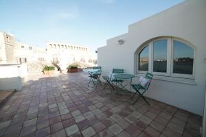 eine Terrasse mit Stühlen, einem Tisch und einem Gebäude in der Unterkunft Dimora del Sedile in Matera