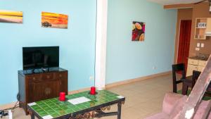 sala de estar con TV y mesa con velas rojas en A4 Plaza Langosta Near the beach 1 bed+2bath loft, en Tamarindo