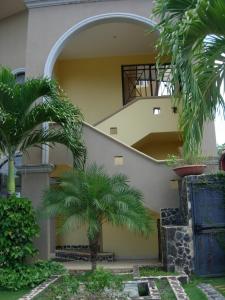 una casa con dos palmeras delante de ella en A4 Plaza Langosta Near the beach 1 bed+2bath loft, en Tamarindo