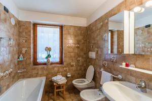 a bathroom with a tub and a toilet and a sink at Agritur Ciasa Dò Parè in Soraga