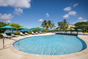 a pool at a resort with chairs and umbrellas at Beach View Hotel in Saint James