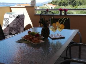 - une table avec deux assiettes de fruits et des verres à vin dans l'établissement Lana i Natali, à Kaštela